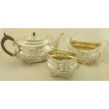 A late Victorian silver three piece Teaset of oblong design with floral border and leaf pattern