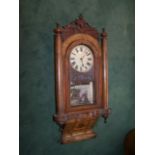 A late 19th century American Wall Clock with white dial and striking movement, in walnut case with