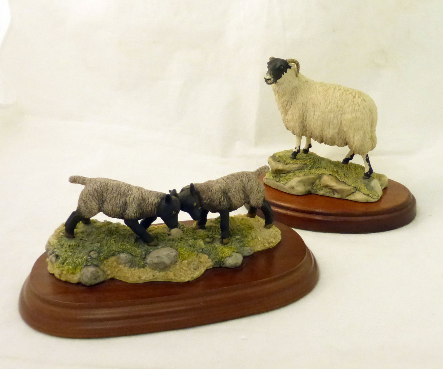 A Border Fine Arts Figure of a black faced ram, and a Border Fine Arts Group of two lambs.