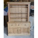 A pine Dresser with boarded canopied Plate Rack, the base with three frieze drawers, two cupboards