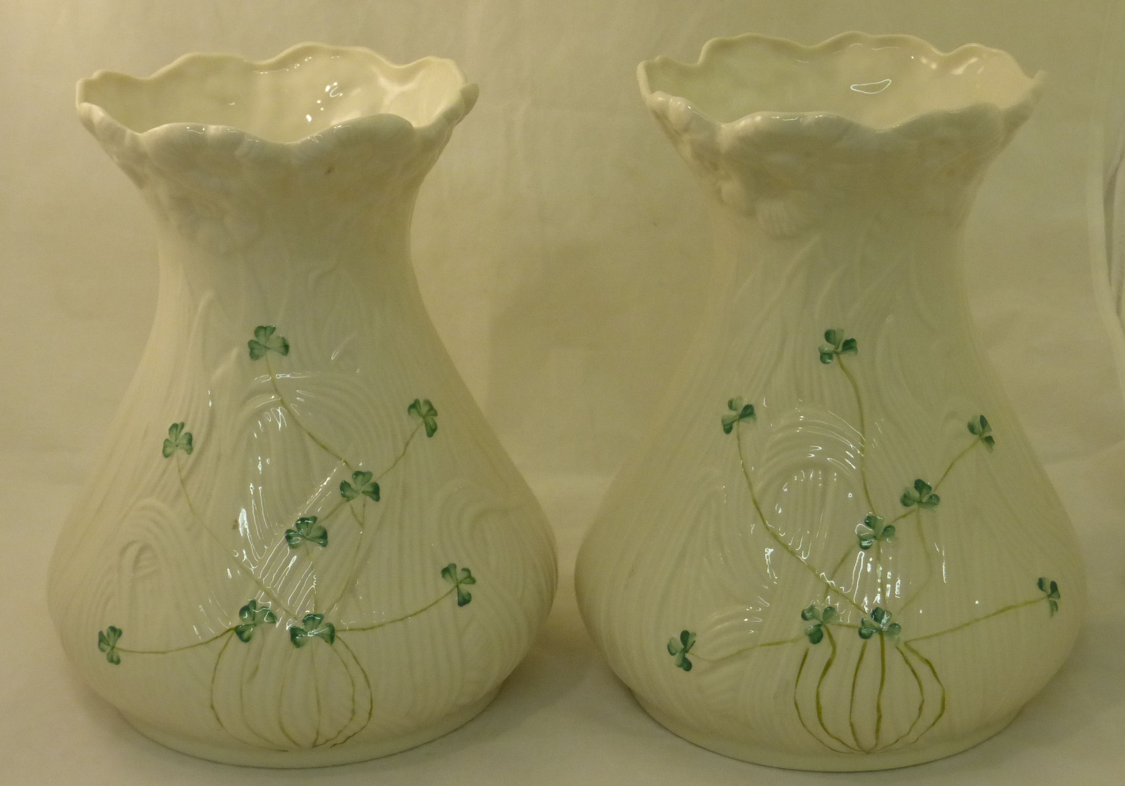 A pair of modern Belleek Vases of waisted design decorated with shamrock on a moulded leaf ground,