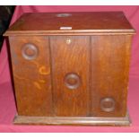 An Edwardian oak Stationery Casket with hinged lid and divided panelled front doors, the interior