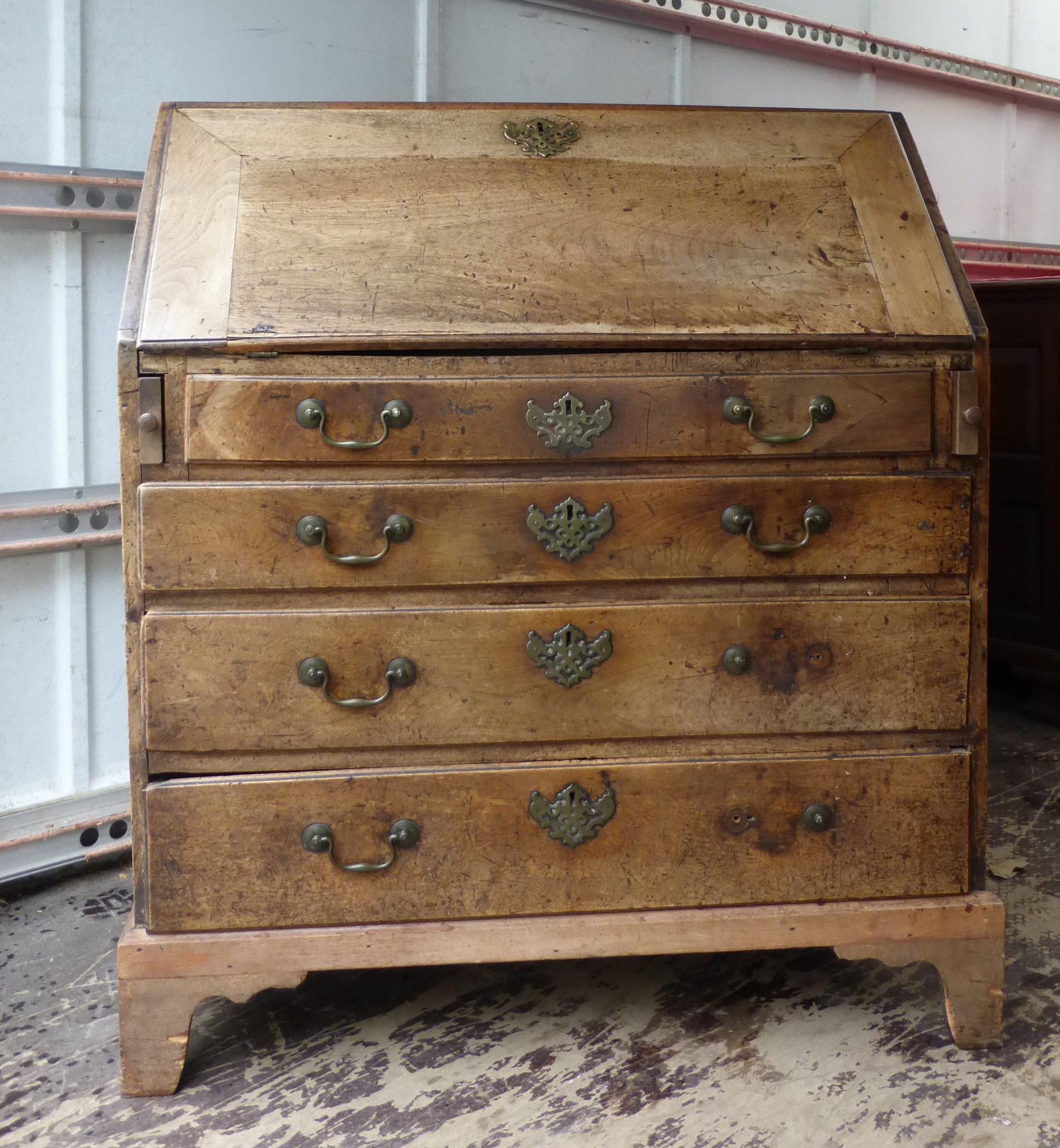 A George III mahogany Bureau, the interior fitted with small drawers, cupboard and pigeon holes,