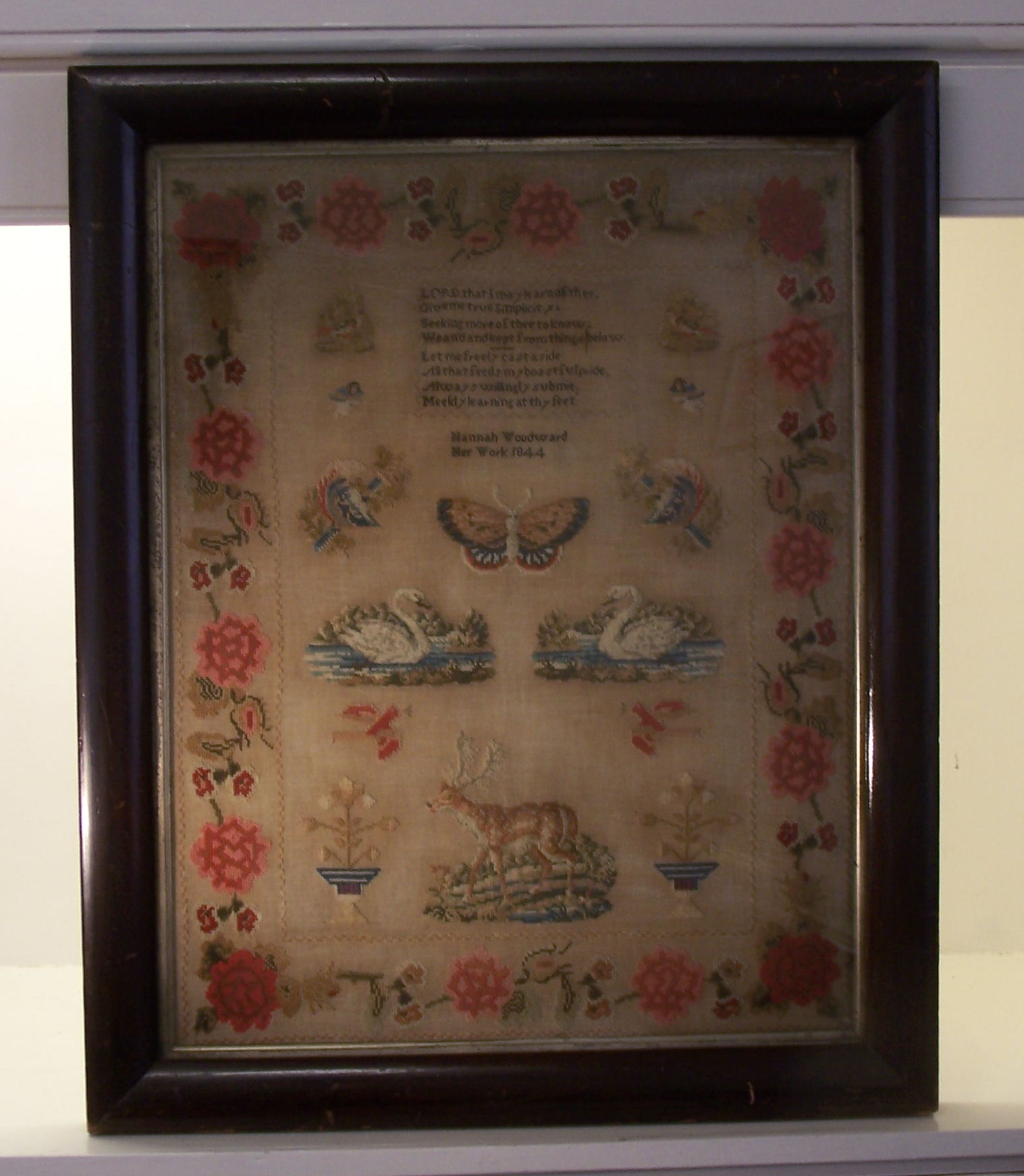 A 19th century Woolwork Sampler by Hannah Woodward 1844, with a prayer, butterfly, swans, stags,