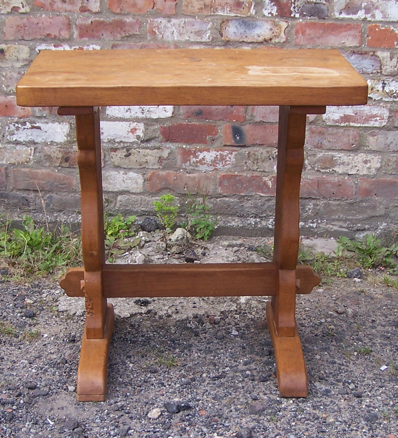 An adzed oak Side Table by Whittaker of Littlebeck, on panel end supports and with carved gnome