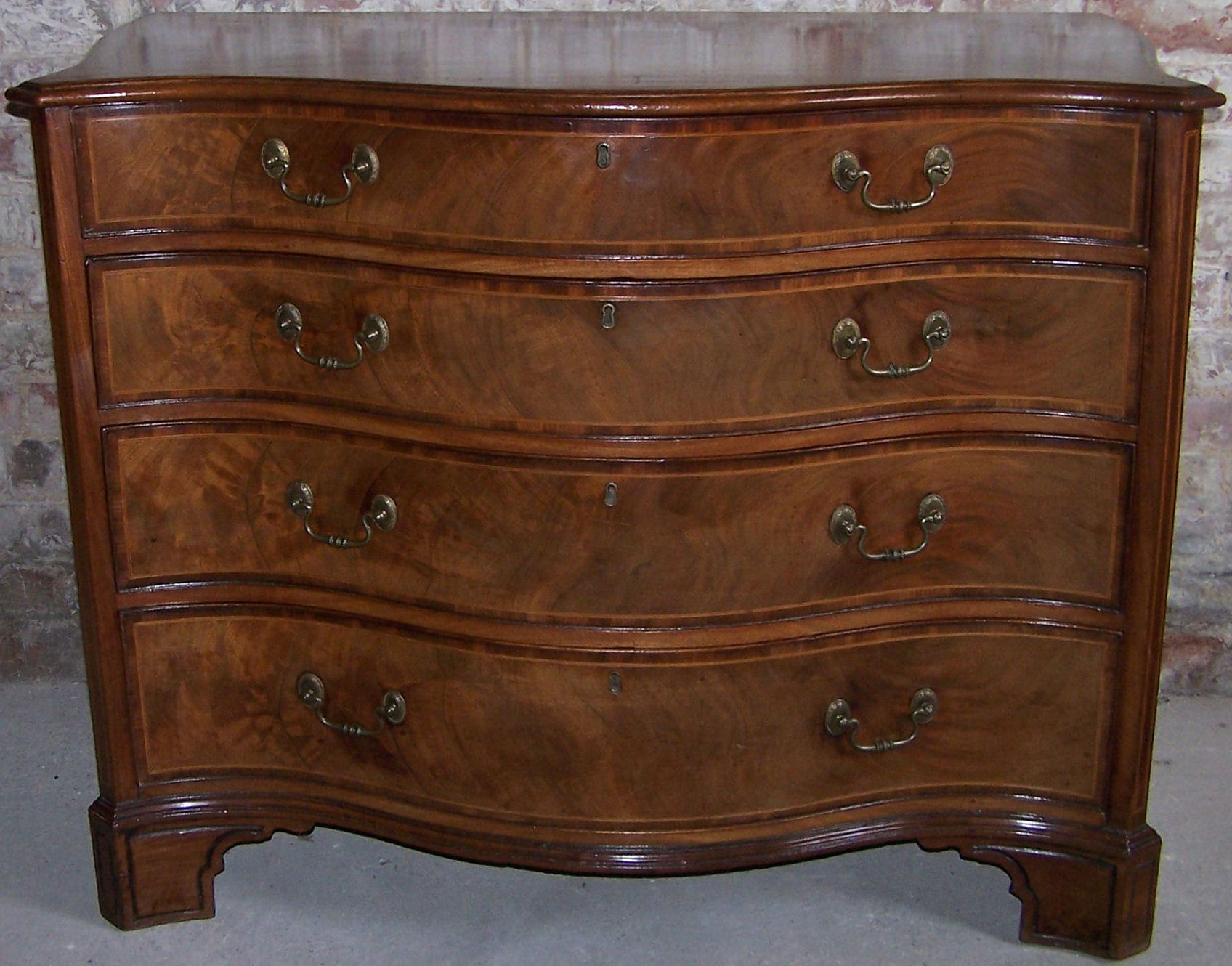 A George III mahogany serpentine fronted Chest of four long graduated drawers with moulded edge