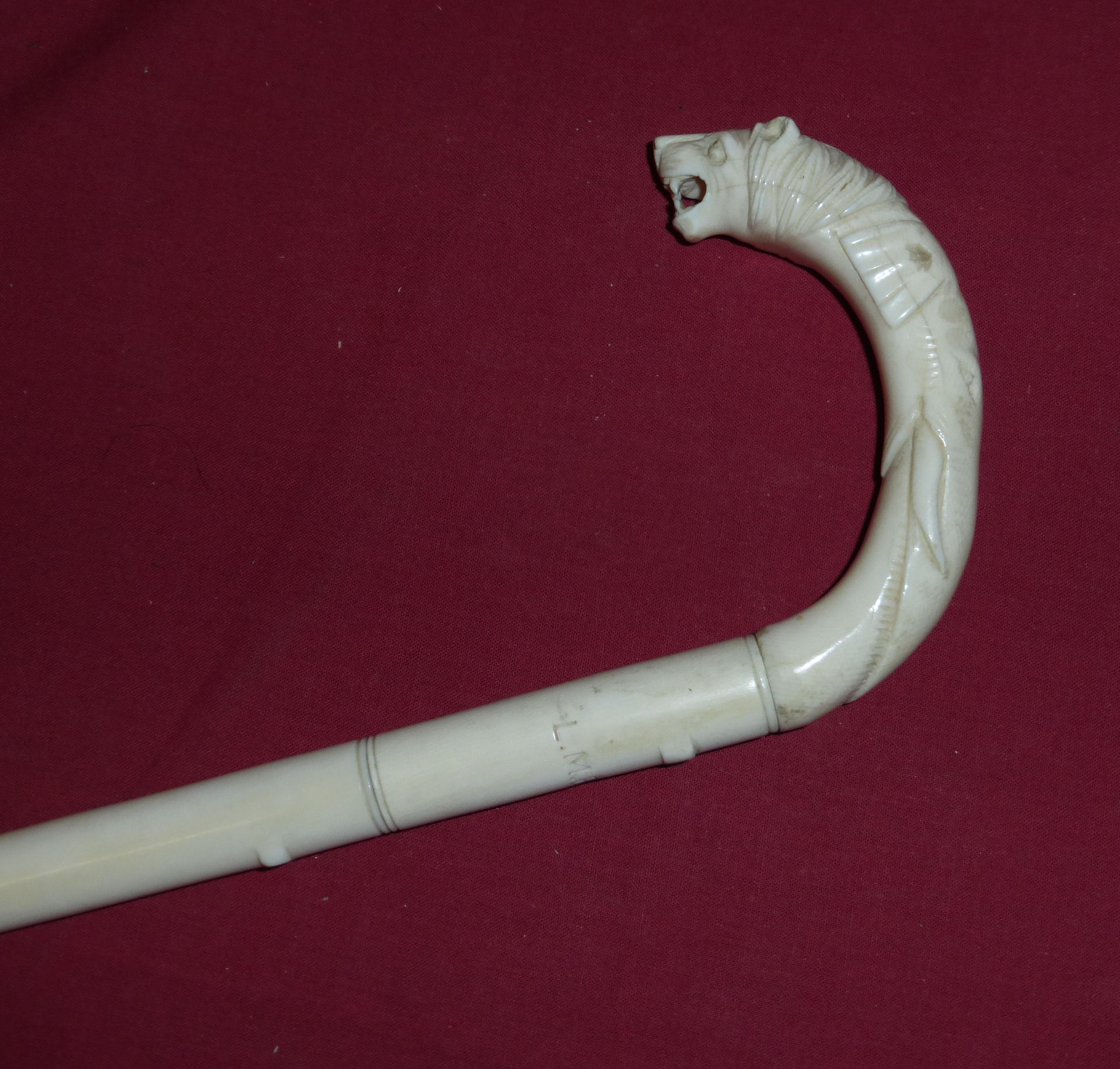 A sectional ivory Walking Stick, the crook handle carved with an elephant and lion, and inscribed "L