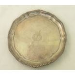 A silver Salver of shaped circular form with gadrooned border on three bracket feet, engraved with