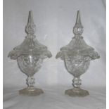 A pair of glass Covered Vases with spear cut finials, fold-over rims and baluster knop stems on