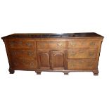 A George III oak Dresser Base with mahogany crossbanding, fitted with a centre drawer with