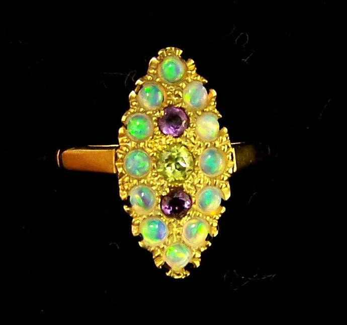 A silver gilt Dress Ring of navette design set with amethyst, peridots and opals.