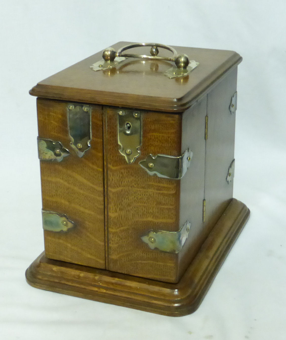 An Edwardian oak Smoker's Cabinet with hinged lid and divided front panelled door, the interior