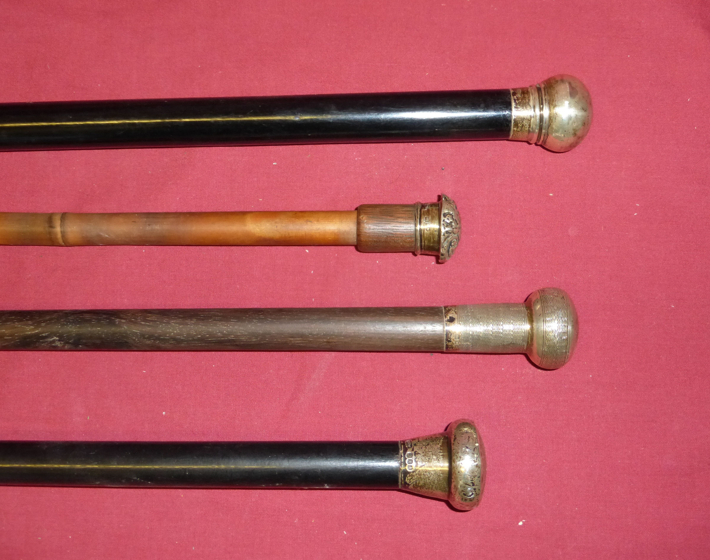 An ebonised Evening Cane with silver top and three other silver mounted Canes.