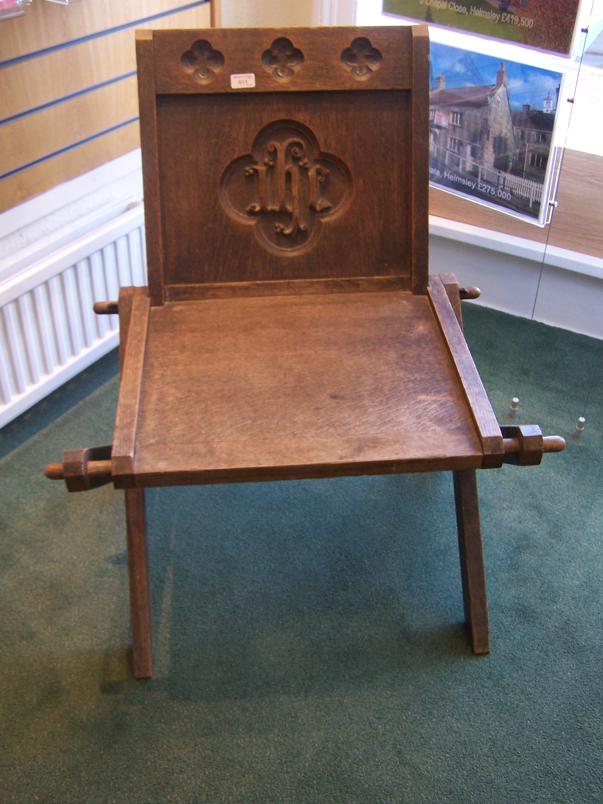 An oak Chapel Chair, the panelled back carved "IHS", on cruciform supports.