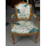 A French bleached walnut open arm Chair with upholstered seat and back, on cabriole supports.