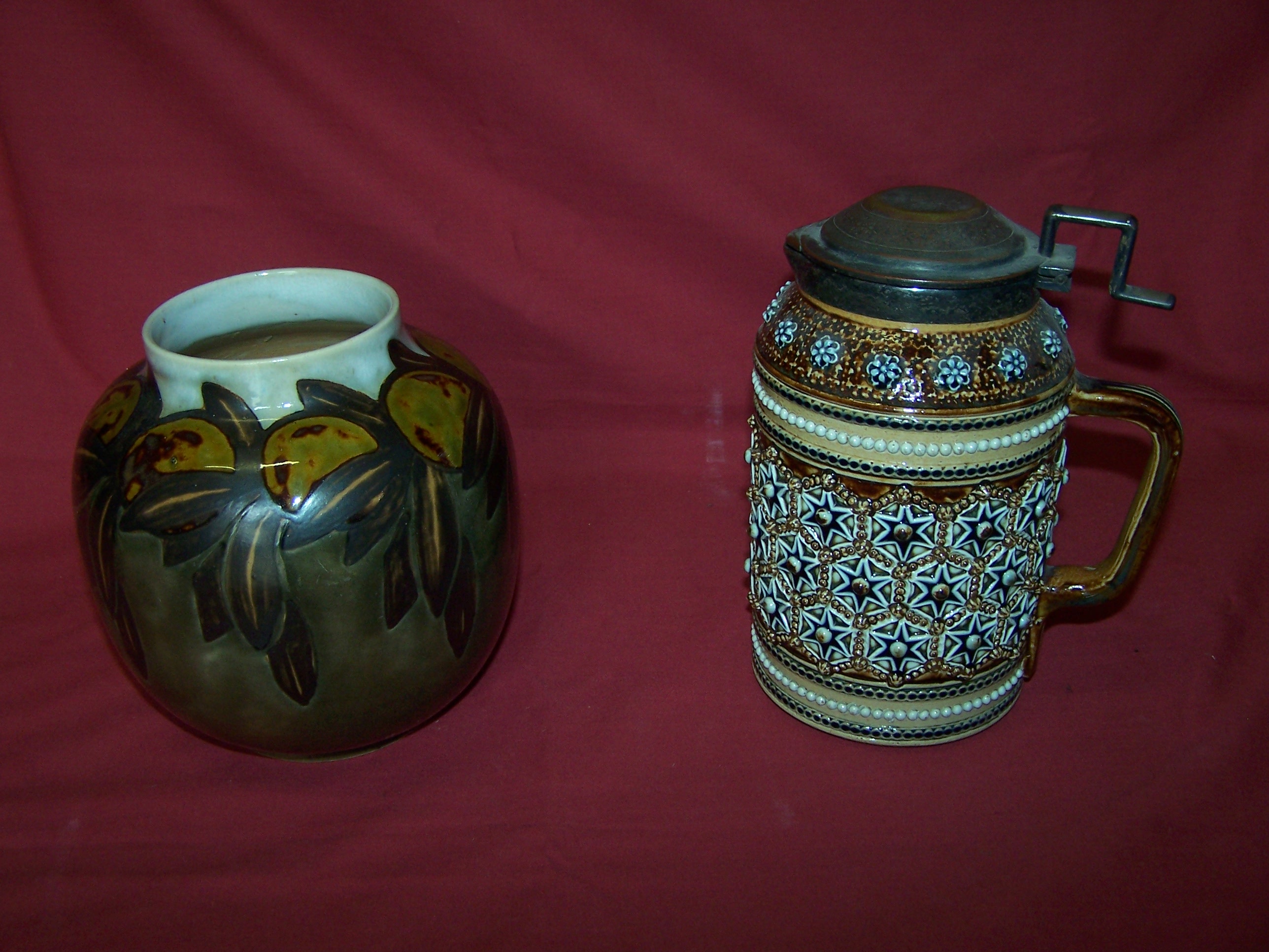 A Doulton Lambeth Lidded Jug with pewter cover and decorated with stylised rosette design, and a