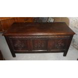 An 18th century oak Coffer with plain hinged lid, the triple panel front with stylised floral