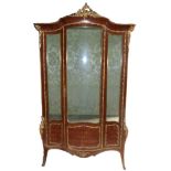 A French king wood Vitrine with ormolu mounts enclosed by a single glazed and panelled door, on