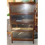 An oak Globe Wernicke four tier sectional Bookcase with glazed up-and-over doors, 2' 10" (86cms)