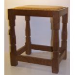 A Thompson of Kilburn "Mouseman" oak oblong Stool with tan hide seat, on panel sided supports with