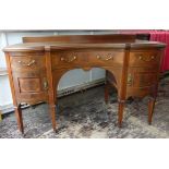 An Edwardian mahogany Kneehole Dressing Table of serpentine outline, with a centre concave fronted