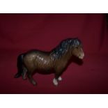 A Beswick model of a Shetland Pony in brown gloss,  no. 1033.  (small ear chip).