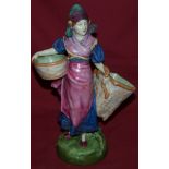 A Royal Dux Figure of a lady carrying two large baskets on a circular base, 10" (26cms) high.