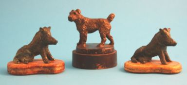 A pair of small Liberty bronze seated wild boars supported on shaped brown leather bases tooled in
