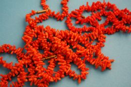Three strands of orange coral necklaces.