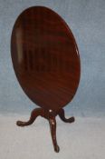 A 19th century mahogany circular tilt top table, supported on a turned central column and cabriole