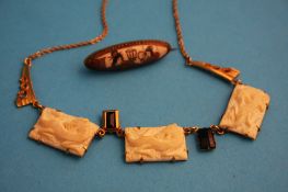 An ivory necklace and a small Japanese Satsuma brooch.