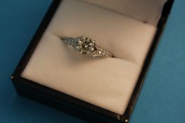 An 18ct white gold diamond solitaire ring, approximately. .80 points, flanked by smaller diamonds to