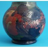 A Moorcroft vase of globular form on a blue ground decorated with birds and fruit, impressed marks.