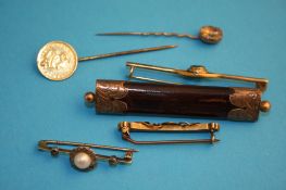 Three gold bar brooches, a gold mounted bar brooch and two stick pins.