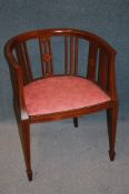 An Edwardian mahogany tub chair with pink upholstered seat supported on square tapering legs