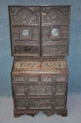 A 19th century Continental carved cabinet, the top with two heavily carved and mirrored doors