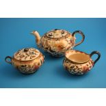 A Zsolany three piece tea set comprising tea pot, sugar bowl and cream jug decorated with gilt edged