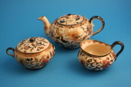 A Zsolany three piece tea set comprising tea pot, sugar bowl and cream jug decorated with gilt edged