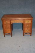 A late Victorian oak pedestal desk with inset top and seven drawers below turned spindles and turned