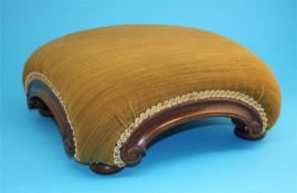 A Victorian mahogany footstool with green overstuffed top each side with scrolled ends, supported on