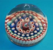 A Victorian glass millefiori paperweight with central coloured cane and four concentric bands of