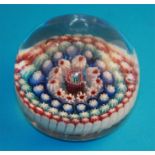 A Victorian glass millefiori paperweight with central coloured cane and four concentric bands of