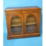 A Victorian walnut pier cabinet with ormolu mounts moulded top below 2 oval glazed doors each with