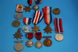 A collection of various unnamed World War I and World War II medals, a World War I Christmas tin