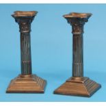 A small pair of silver Corinthian column candlesticks supported on stepped square bases, London