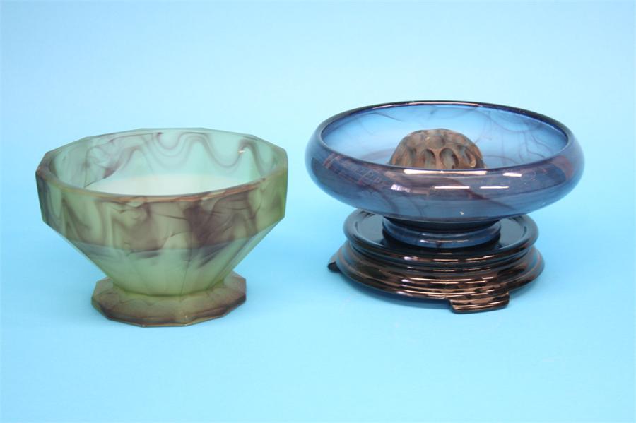 A Davidsons purple cloud glass bowl and stand on a blue ground and another bowl on a pale green