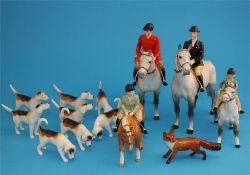 A Beswick hunting group comprising huntsman and huntswoman on dappled grey horses, a boy on a