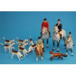 A Beswick hunting group comprising huntsman and huntswoman on dappled grey horses, a boy on a