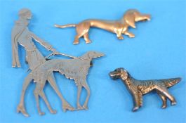 A 1930's Art Deco brooch showing a lady walking with her Afghan hound and two other dog brooches. (