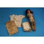 A continental doll with glass eyes and leather clad body, dolls clothes, evening bag etc.